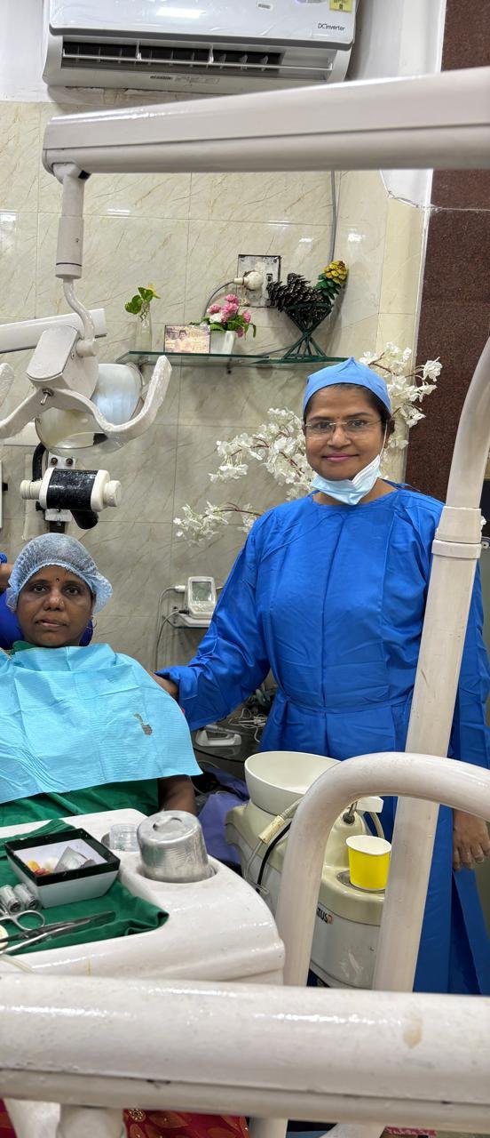 Dr. Alka Khade in blue scrubs with a patient